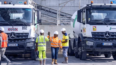 Equipe ouvriers devant des camions ciments
